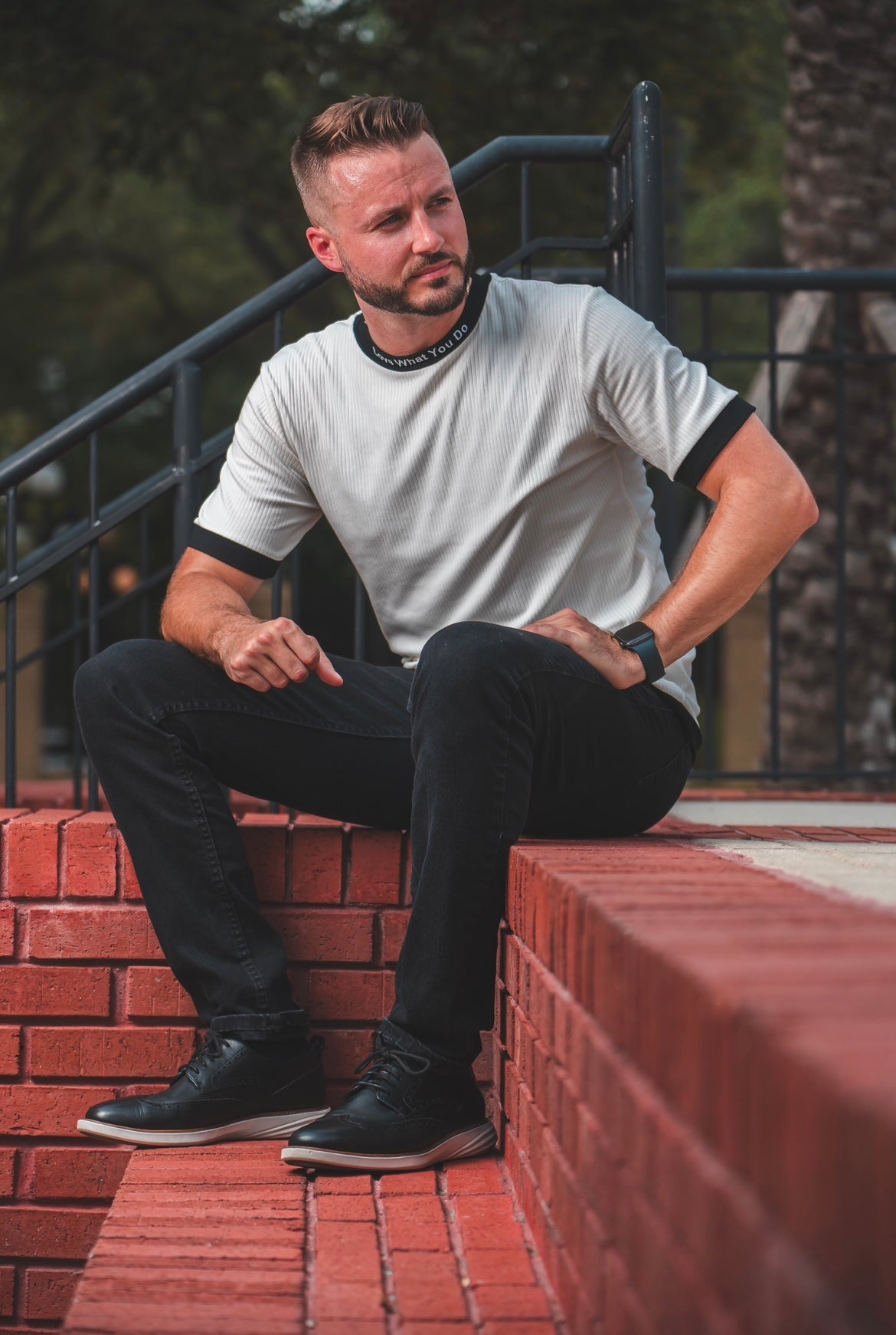 Man wearing merakitay ribbed two tone tee. Ribbed two tone black and white dressy tee. Embroidered neckline love what you do and embroidered logo. Crew neck and fitted neckline. Nonbinary, unisex, gender-neutral ribbed tee. 