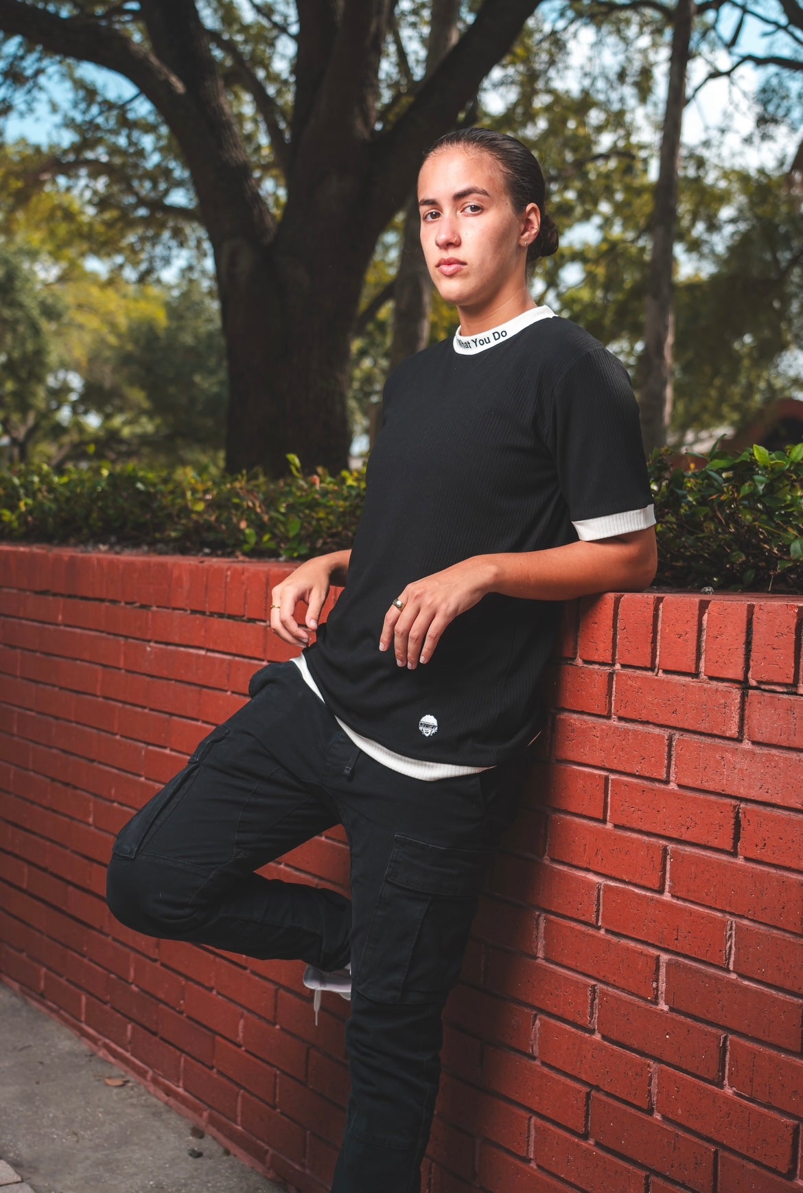 Woman weaking merakitay ribbed tee. Ribbed two tone black and white dressy tee. Embroidered neckline love what you do and embroidered logo. Crew neck and fitted neckline. Nonbinary, unisex, gender-neutral ribbed tee. 