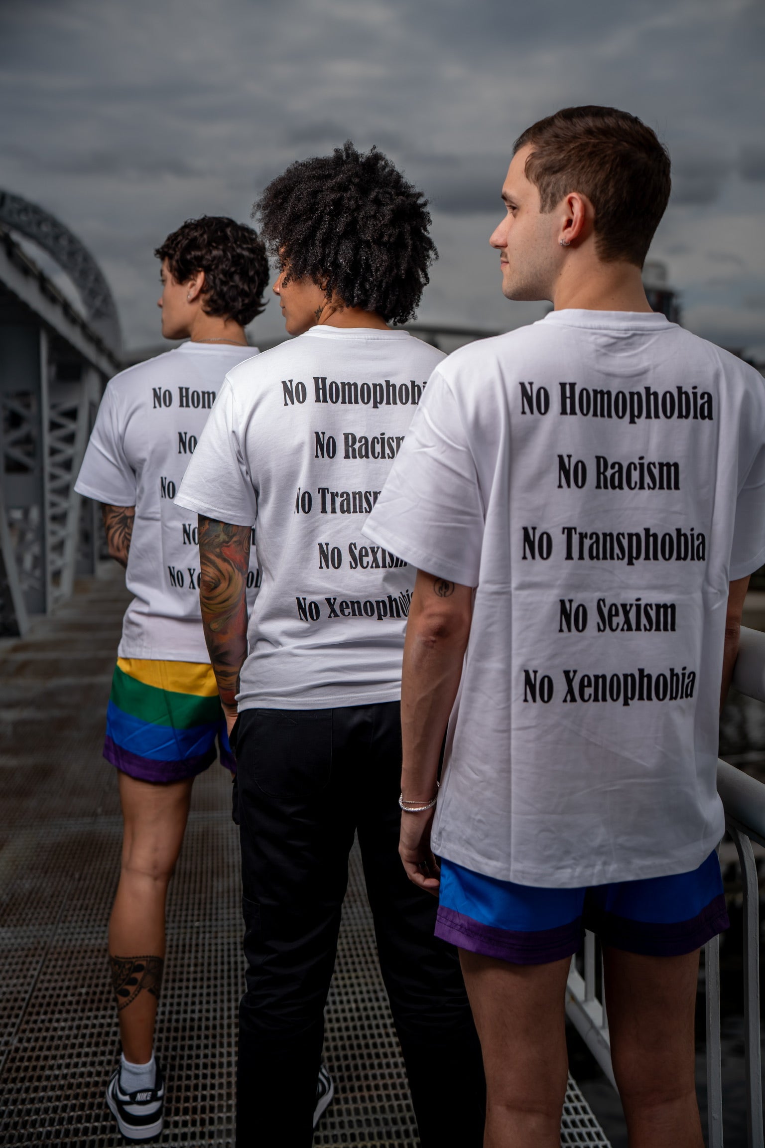 2 women and 1 man wearing the no hate merakitay statement tee. MerakiTay no hate tee. Gaylations, love wins. Screenprinted and embroidered logo. No homophobia tee, no xenophobia, no sexism, no violence, no racism, no xenophobia, spread love, no discrimination, no hate tee. Crew neck, soft material, thick material. Tighter neckline. Nonbinary and unisex. 