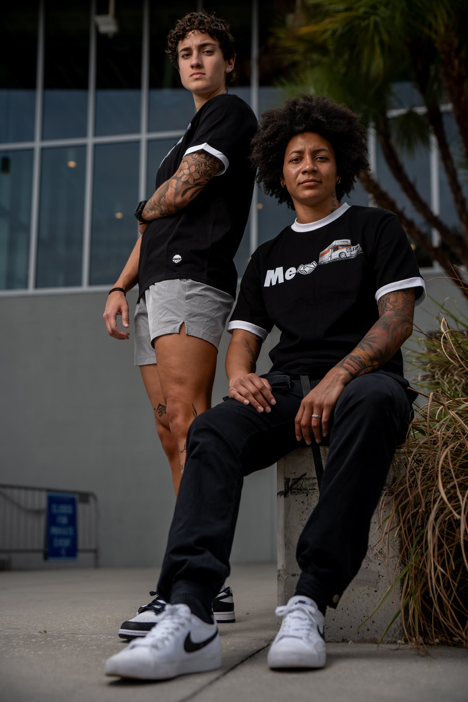 2 women wearing Uhaul tees. Two lesbians wearing uhaul inside joke tees. 2 tone black and white tee shirt with words me handshake uhaul. Embroidered loo, crew neckline. Thick material, Lesbian joke pride tee shirt. 